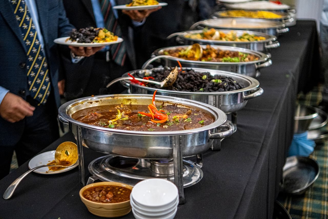 Elegant buffet display with various dishes served in warmers at a catered event.